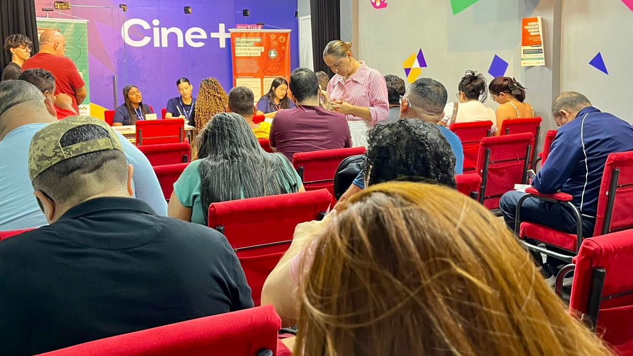 pessoas sentadas em uma sala com carteiras